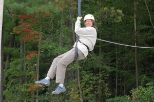 Photo of Sandy riding the giant swing at Camp Bryn Mawr near Honesdale, PA on team building day.